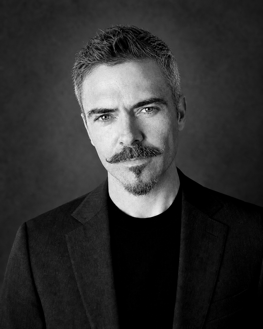 Black-and-white editorial portrait of James Allister Odd in a dark jacket